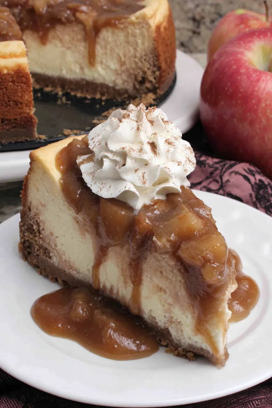 Slice of apple butter cheesecake topped with whipped cream