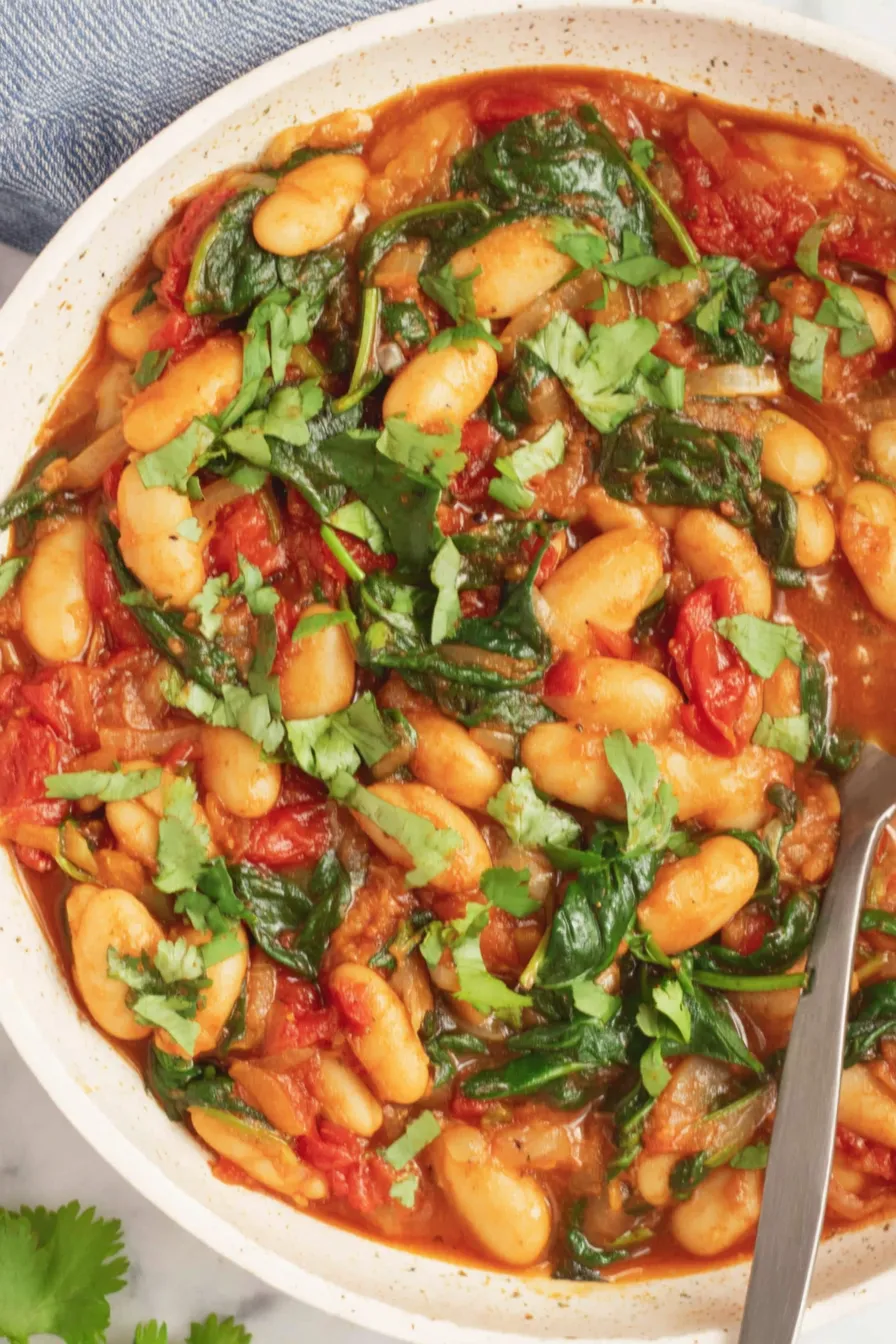 Butter bean stew in a skillet with cilantro garnish