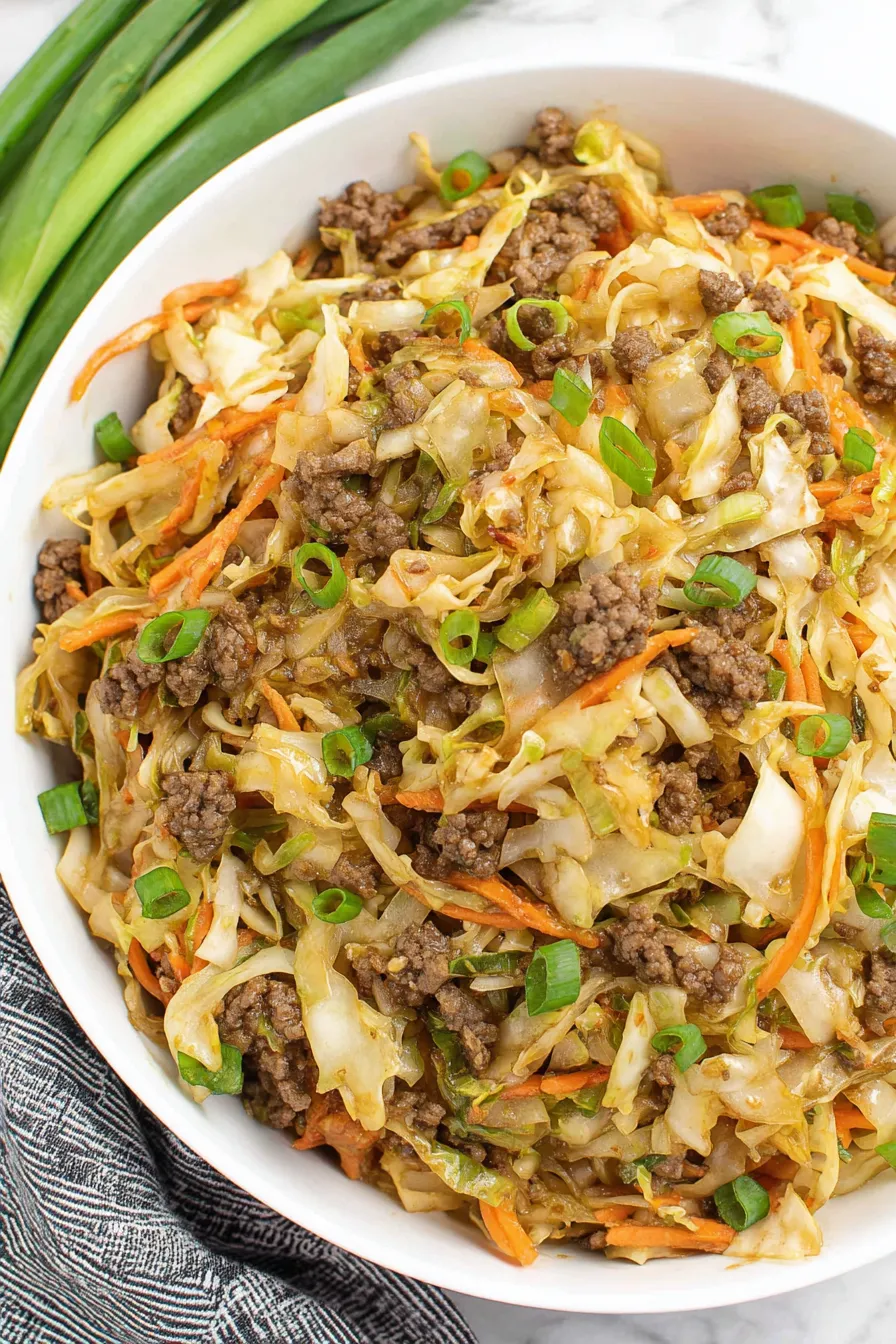 Finished egg roll in a bowl garnished with green onions