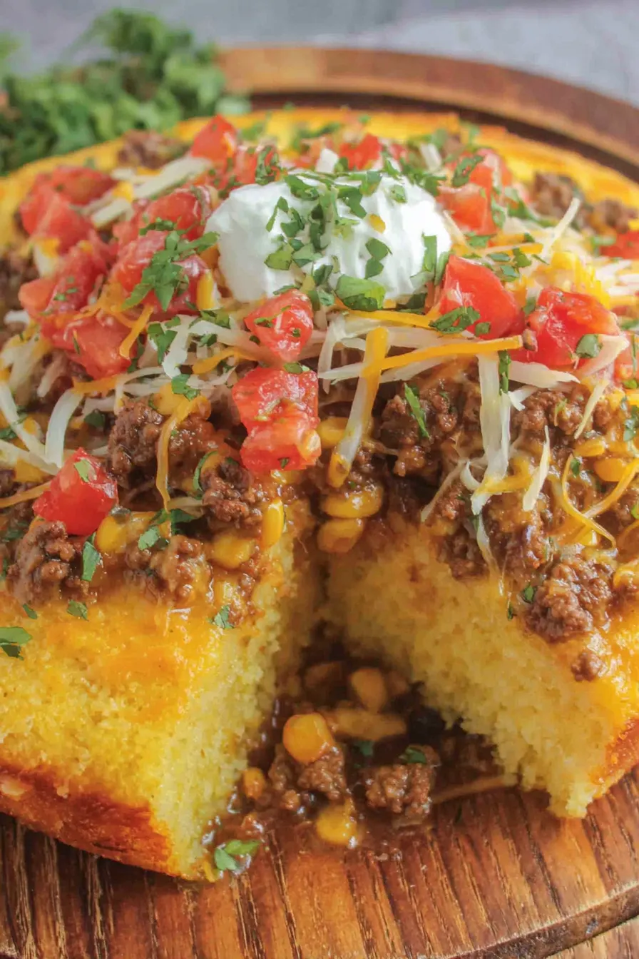 Close-up of cornbread topping with melted cheese beneath
