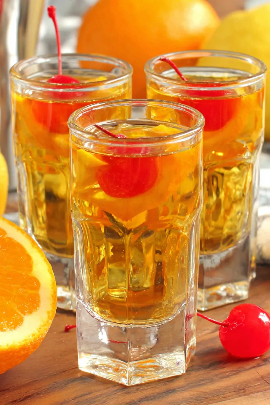 Three bottles and shot glasses with citrus garnishes