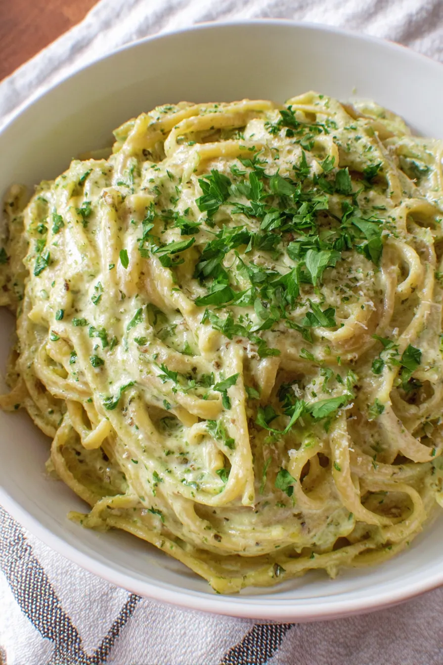 Creamy pesto pasta in a bowl with fresh basil