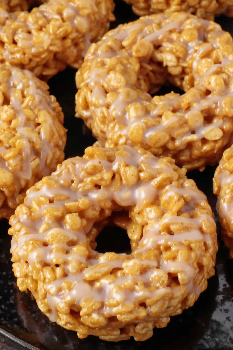 Maple cinnamon glazed pumpkin Rice Krispies donuts on a rack