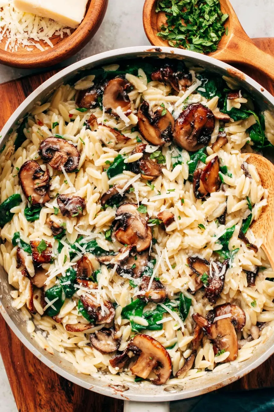 Creamy garlic mushroom orzo in a shallow bowl with basil