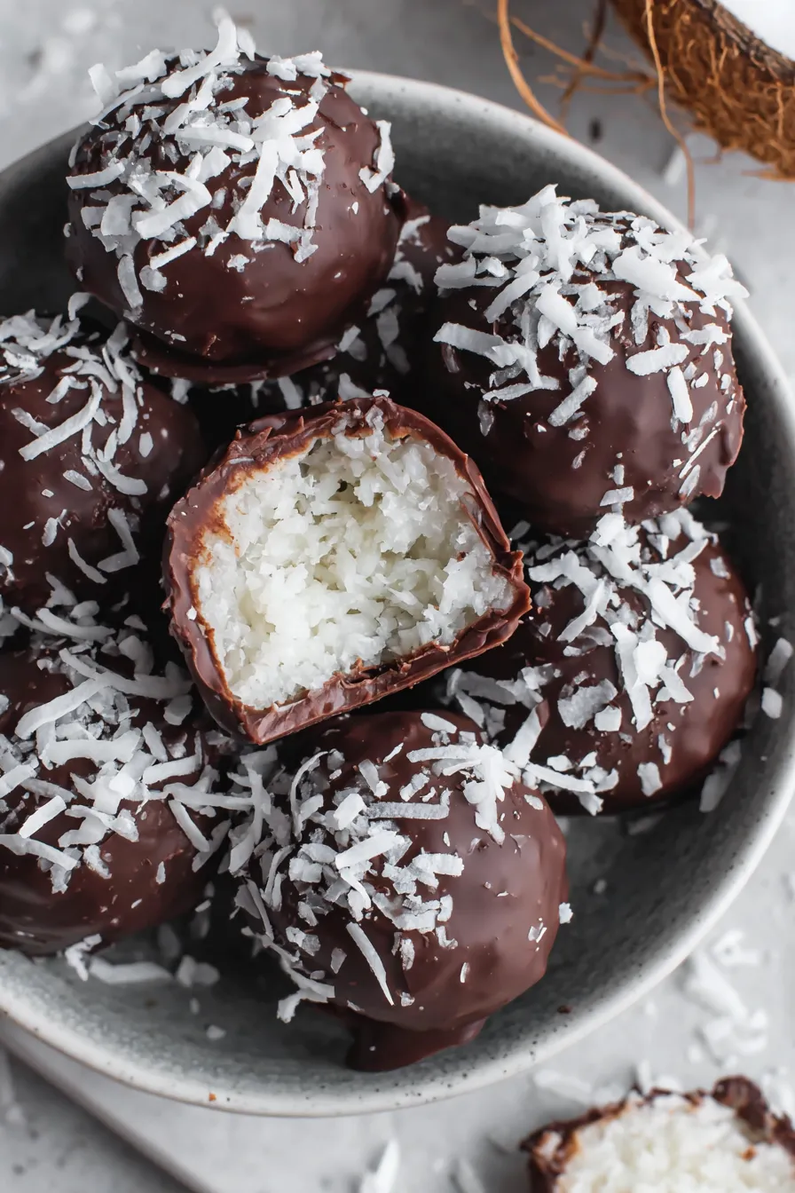 Finished chocolate covered coconut balls arranged on parchment