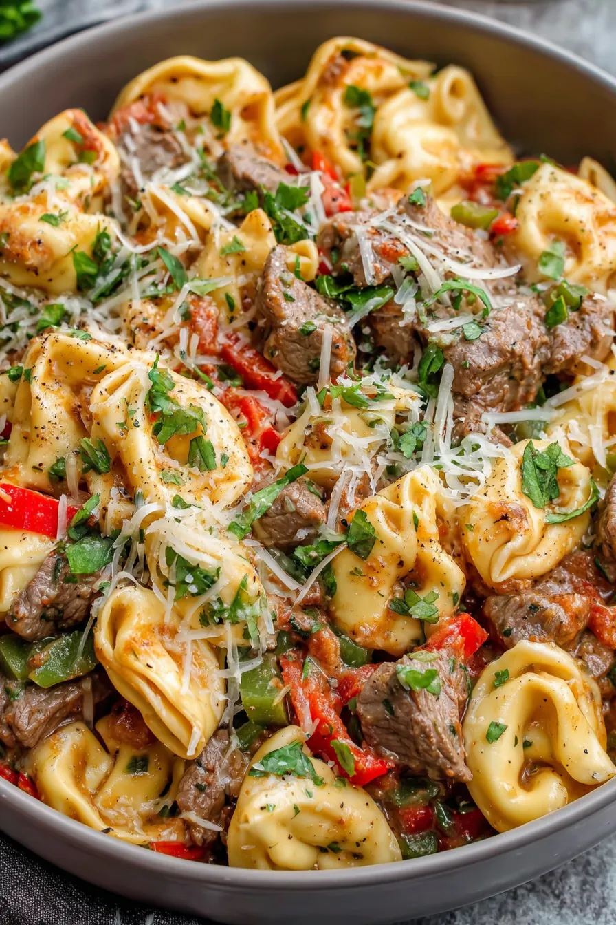 Serving spoon scooping cheesesteak tortellini