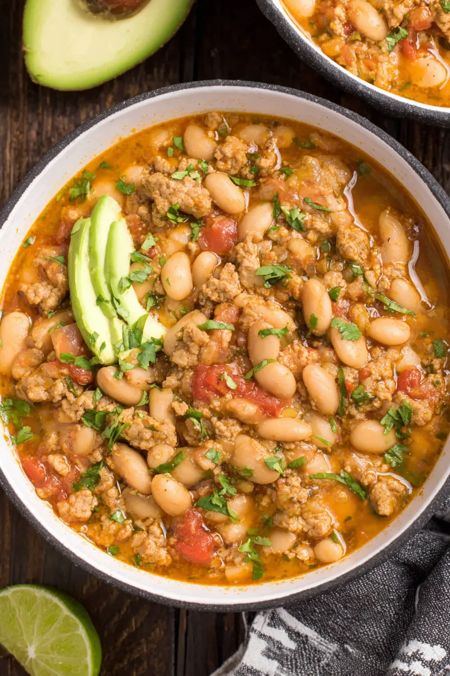 Bowl of chili garnished with cilantro and lime