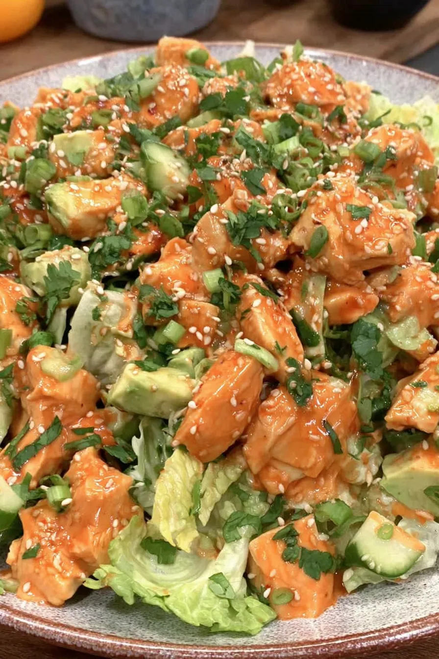 Shredded Korean BBQ chicken mixed with gochujang yogurt dressing in a bowl