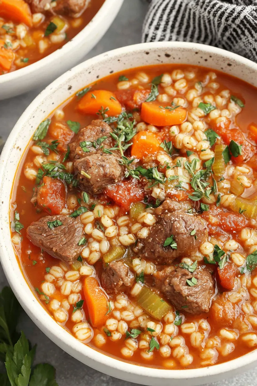 Simmering pot of beef and barley soup with vegetables