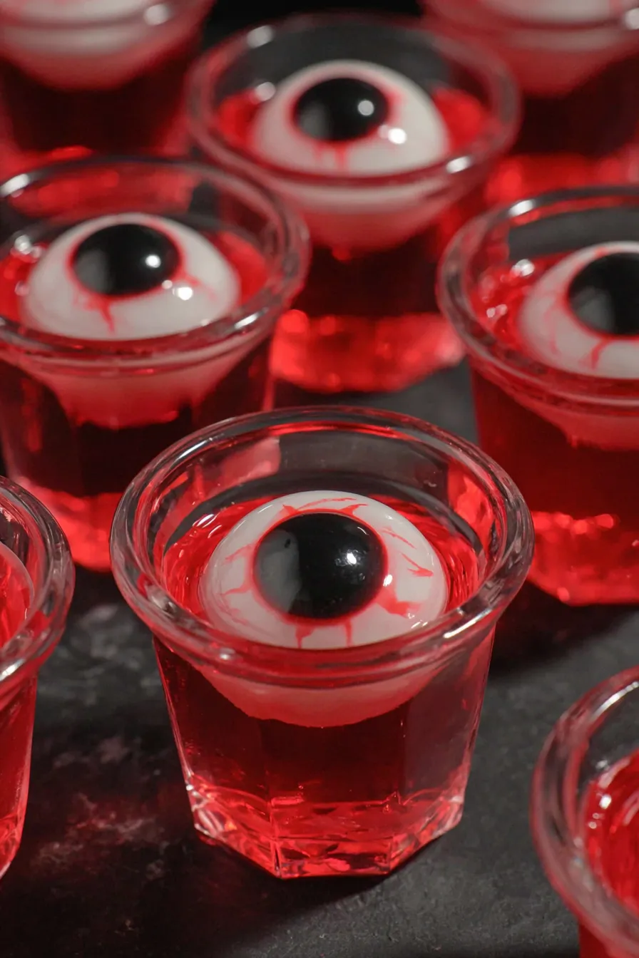 Red berry gelatin in shot glasses with candy eyeballs