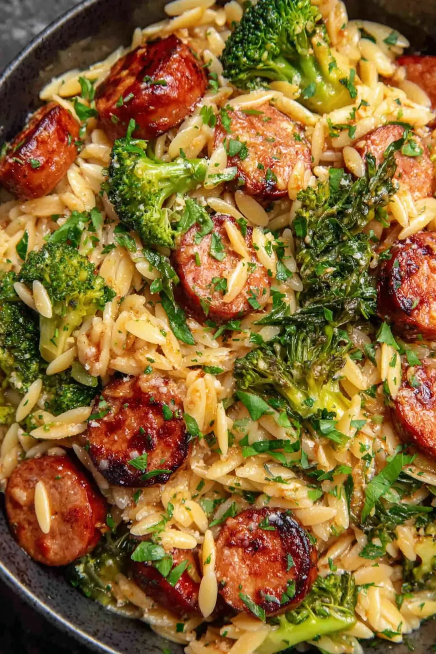Chicken sausage and broccoli orzo in a pot, finished with grated Parmesan