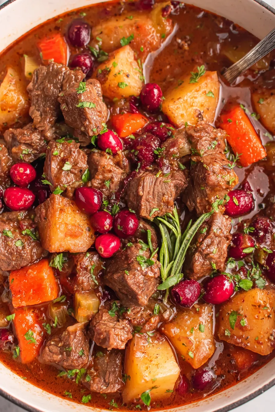 Cranberry Apple Beef Stew in a pot with parsley garnish