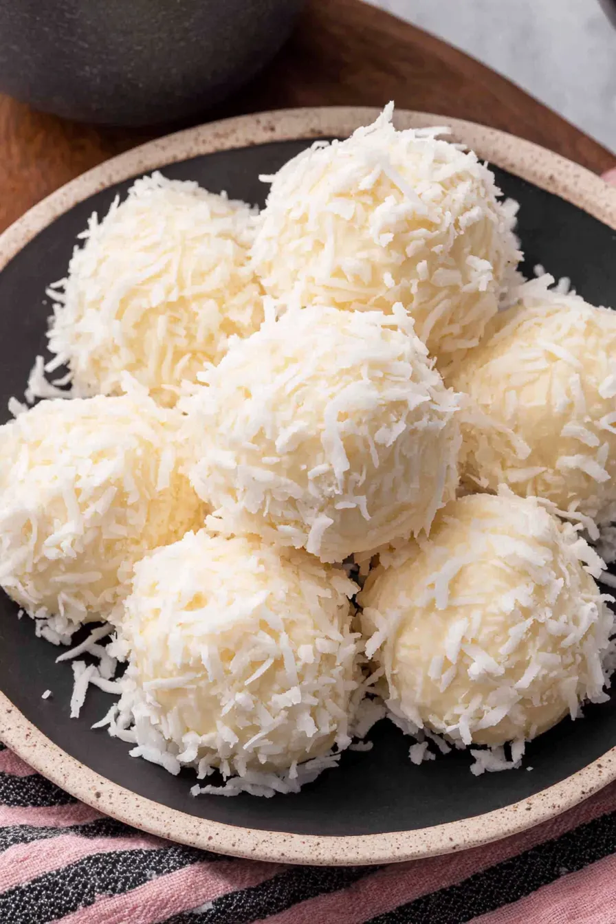 Coconut snowballs on parchment, some coated and some uncoated