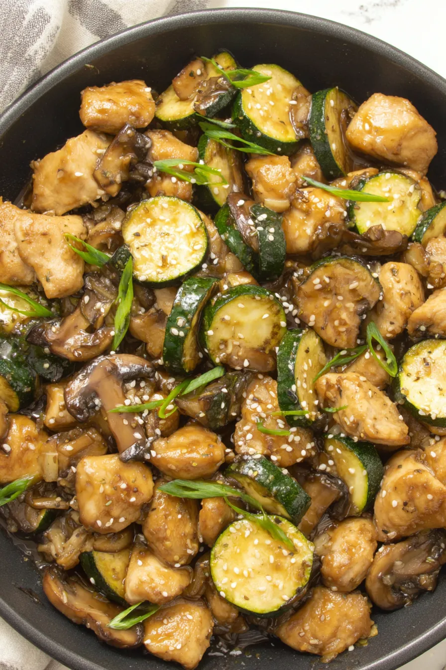 Cooked mushroom chicken in a skillet garnished with sesame seeds