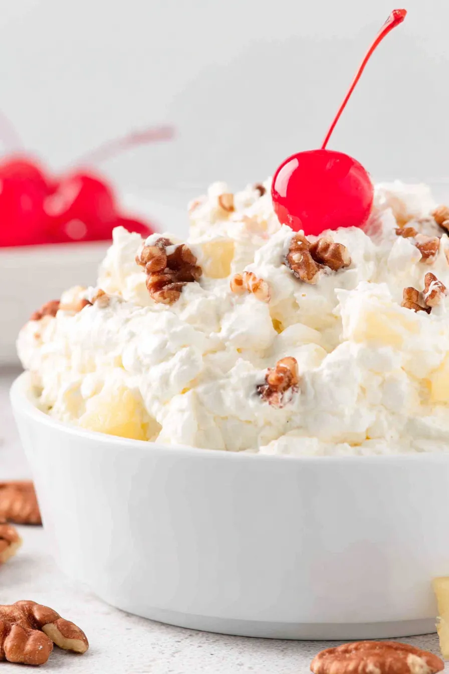 Piña Colada Fluff in a glass bowl with coconut on top