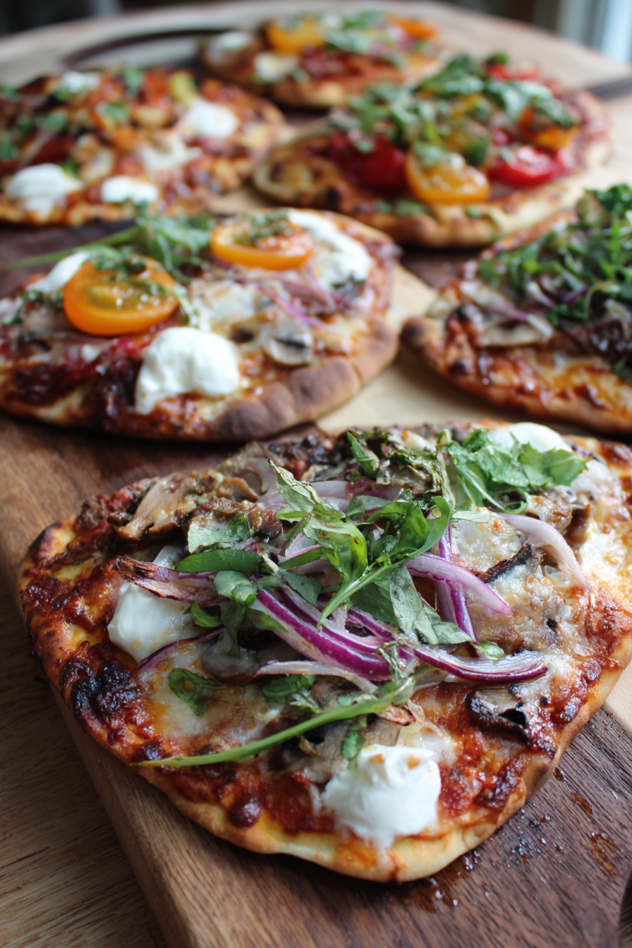 Autumn naan pizzas on a baking sheet with sage