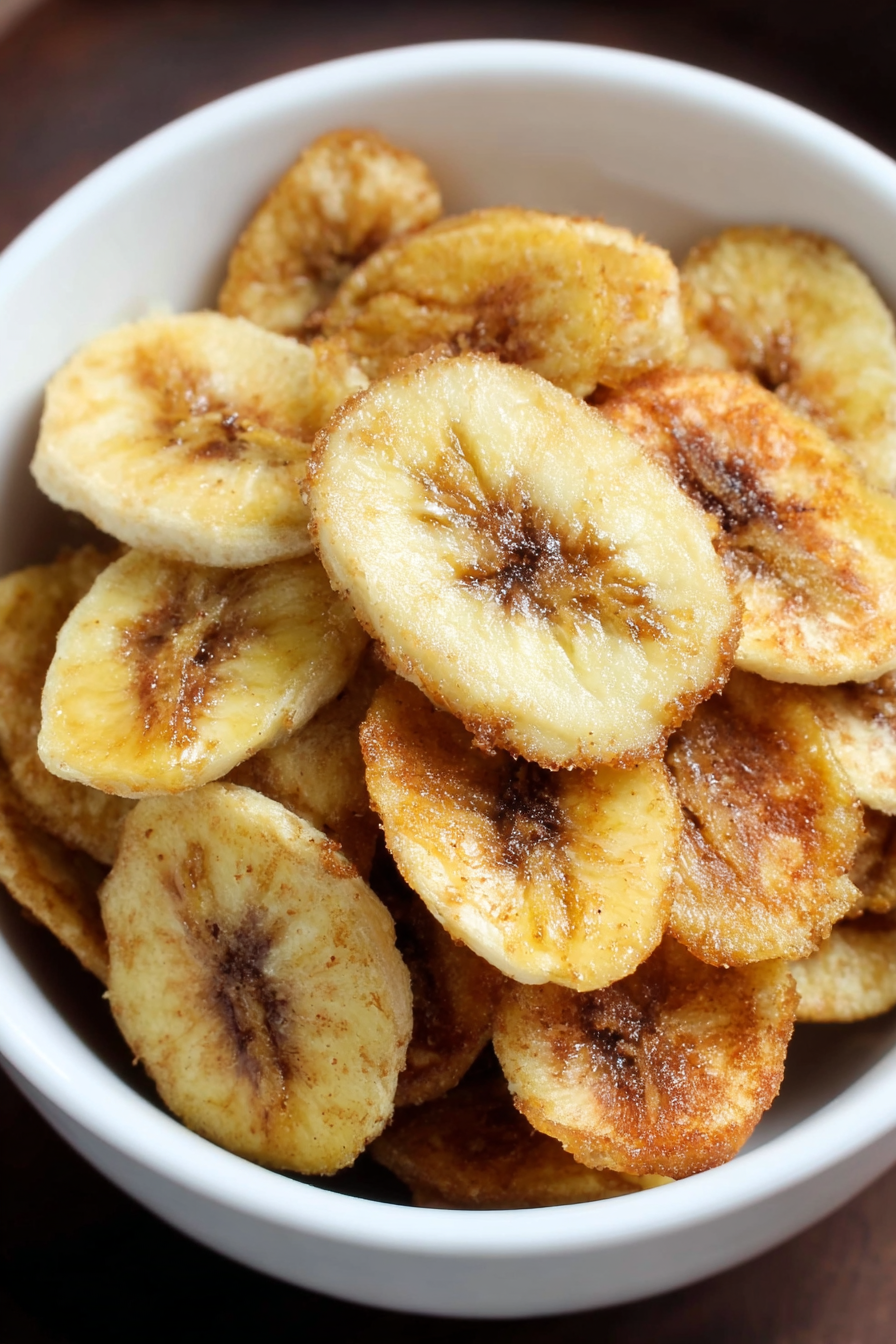 Banana slices in a bowl tossed with olive oil