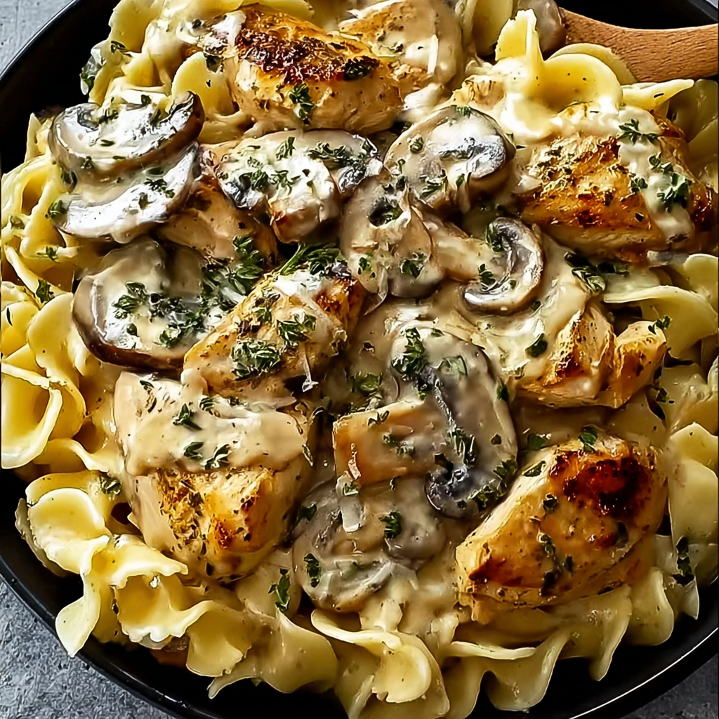 Creamy garlic chicken and mushroom fettuccine in a skillet